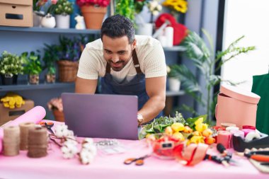 Çiçekçide çalışan İspanyol bir çiçekçi dizüstü bilgisayar kullanıyor.