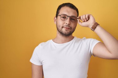 İspanyol gözlüklü, düşünceli, aklı başında, kendine güvenen bir adam. 