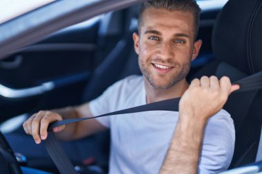 Sokakta kendine güvenen beyaz bir adam gülümsüyor.