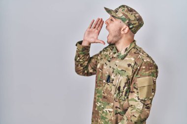 Kamuflaj üniforması giyen genç İspanyol adam el ele tutuşarak bağırıyor ve bağırıyordu. iletişim konsepti. 