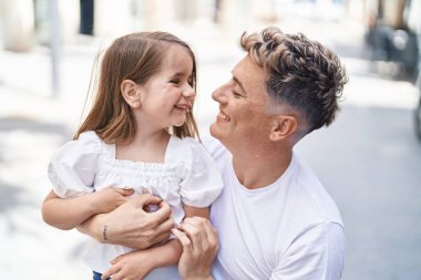 Father and daughter smiling confident hugging each other at park