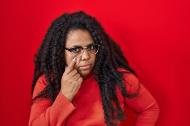 Ayrıca kırmızı arka planda dikilmiş İspanyol bir kadın senin jestini ve şüpheli ifadeni izliyor. 