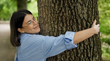 Viyana 'da parkta ağaca sarılan güzel İspanyol bir kadın.
