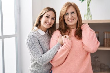 Anne ve kızı evde birbirlerine sarılıyorlar.