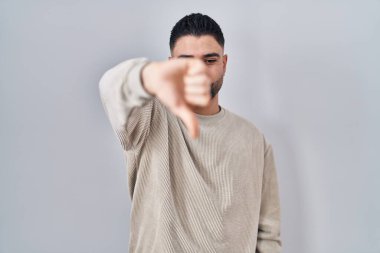 Tecrit edilmiş arka planda duran genç yakışıklı adam mutsuz ve kızgın görünüyor. Reddedilmiş ve olumsuz bir hareket sergiliyor. Kötü ifade. 