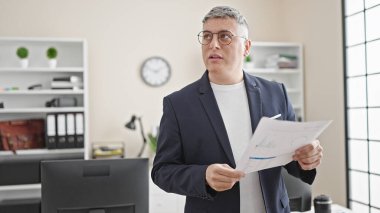 Genç Kafkasyalı iş adamı ofiste belge okuyor.