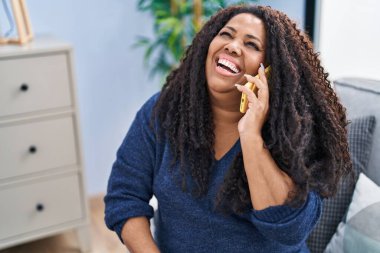Afro-amerikan kadın akıllı telefonuyla konuşuyor.