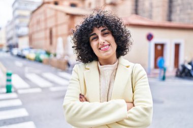 Young middle east woman excutive smiling confident standing with arms crossed gesture at street