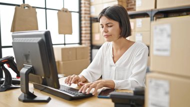 Ofisteki bilgisayarı kullanan genç ve güzel İspanyol bir iş adamı.