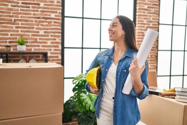 Genç, güzel, İspanyol bir mimar. Kendine güvenen bir mimar. Elinde yeni evimizin planları ve şapkası var.