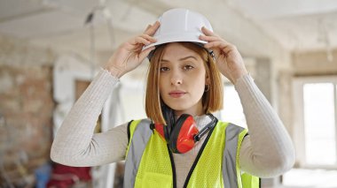 İnşaat alanında rahat bir ifadeyle duran genç sarışın mimar.