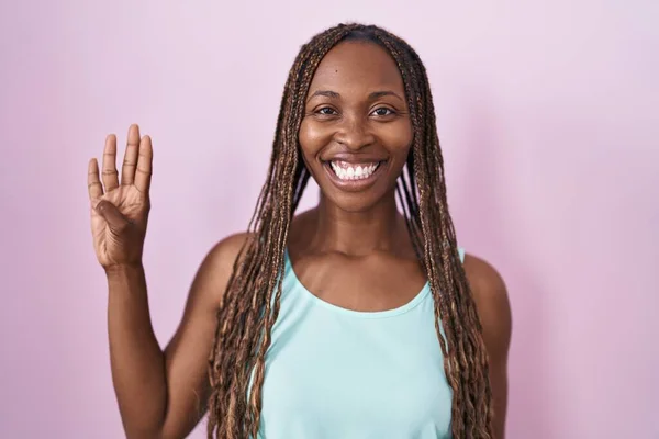Африканская Американка Стоит Розовом Фоне Показывает Пальцами Номер Четыре Улыбаясь — стоковое фото