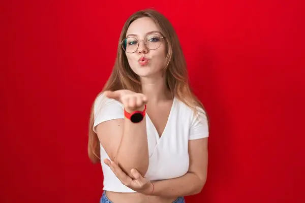 Jeune Femme Caucasienne Debout Sur Fond Rouge Regardant Caméra Souffler — Photo