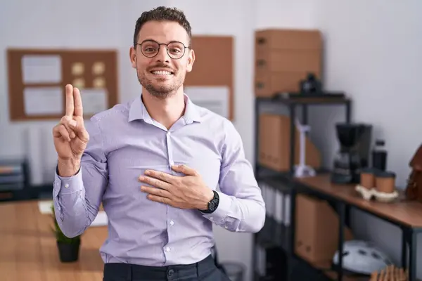 Young Hispanic Man Office Smiling Swearing Hand Chest Fingers Making — Stock Photo, Image