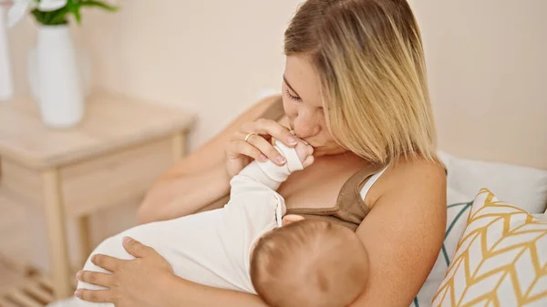 妈妈和女儿坐在床上 母乳喂养婴儿 在卧室里亲吻手 — 图库照片
