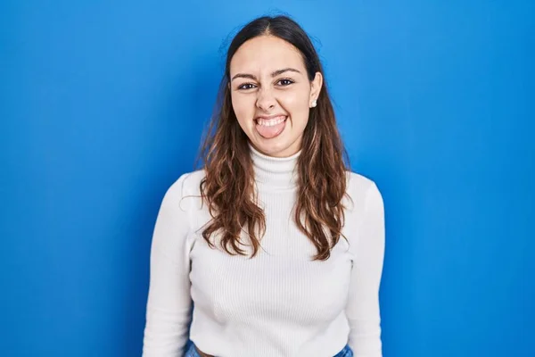 Ung Latinamerikansk Kvinna Står Över Blå Bakgrund Sticker Tungan Glad — Stockfoto