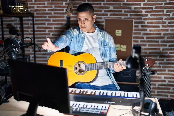 Joven Hispano Tocando Guitarra Clásica Estudio Música Señalando Con Dedo —  Fotos de Stock