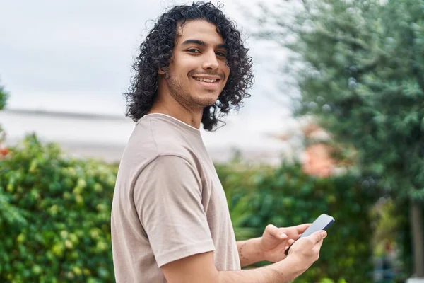 Νέοι Λατίνος Άνθρωπος Χαμογελά Αυτοπεποίθηση Χρησιμοποιώντας Smartphone Στο Πάρκο — Φωτογραφία Αρχείου