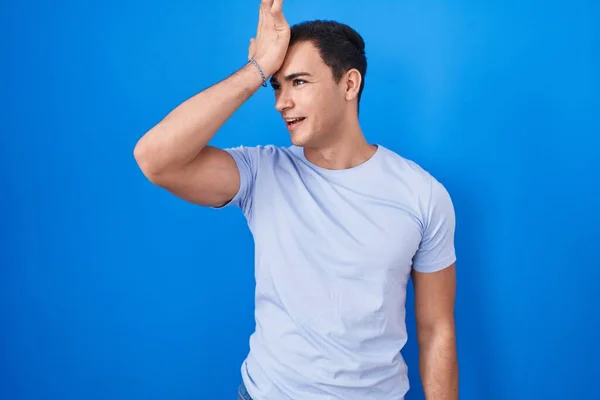 Homem Hispânico Jovem Sobre Fundo Azul Surpreso Com Mão Cabeça — Fotografia de Stock