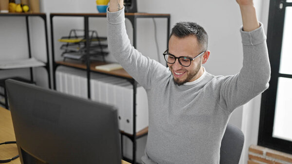 Hispanic man business worker using computer celebrating at office