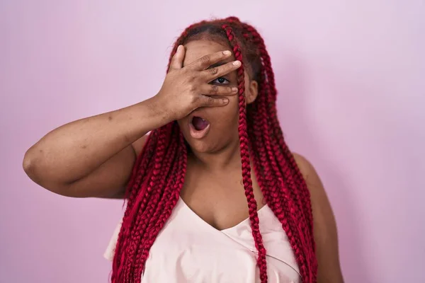 Африканская Американка Плетеными Волосами Стоящая Розовом Фоне Подглядывая Шокирующие Закрывающие — стоковое фото