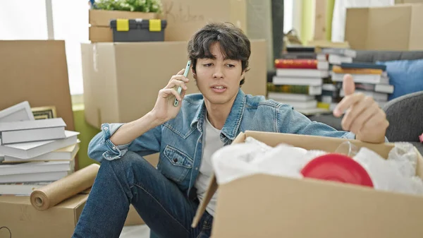 Молодой Латиноамериканец Говорит Телефону Распаковывая Картонную Коробку Новом Доме — стоковое фото