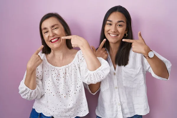 西班牙裔母亲和女儿一起笑容满面 用手指 牙齿和嘴指指点点 牙齿健康概念 — 图库照片