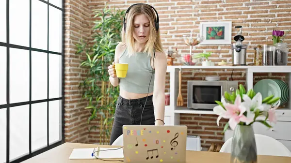 Mujer Rubia Joven Escuchando Música Tomando Café Con Expresión Relajada — Foto de Stock