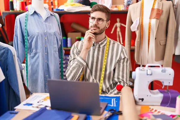 有胡子的西班牙男人在裁缝店用笔记本电脑认真地思考着手托着下巴的问题 思考着困惑的想法 — 图库照片