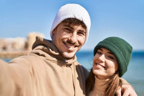 stock image Mand and woman couple hugging each other make selfie by camera at seaside