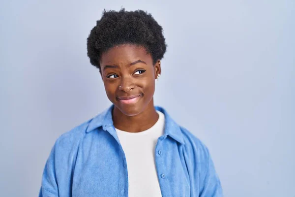 African American Woman Standing Blue Background Smiling Looking Side Staring — Stockfoto