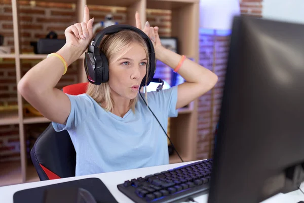 Νεαρή Καυκάσια Γυναίκα Που Παίζει Βιντεοπαιχνίδια Φορώντας Ακουστικά Κάνει Αστεία — Φωτογραφία Αρχείου