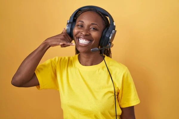 Африканская Американка Слушает Музыку Используя Наушники Улыбаясь Делая Телефонный Жест — стоковое фото