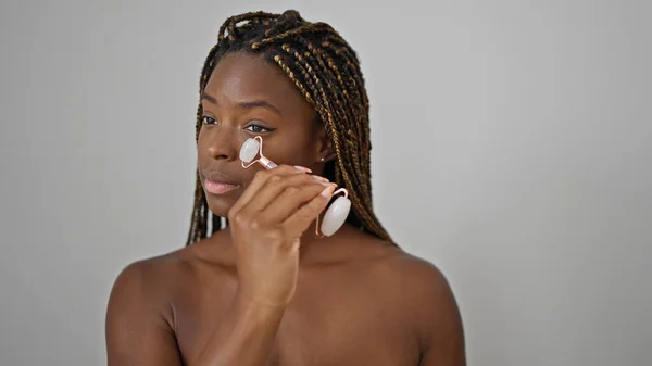 非洲裔美国妇女在孤立的白色背景上用皮肤健身房按摩脸 — 图库照片