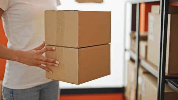 Африканская американка, торговец в электронной коммерции, ставит пакеты на полки в офисе