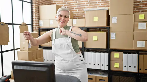 中年白发苍苍的女性电子商务工作者微笑着自信地在办公室跳舞 — 图库照片
