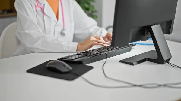 Young blonde woman doctor typing on computer working at clinic
