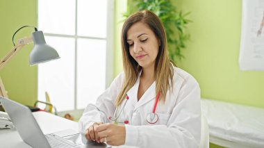 Orta Doğulu kadın doktor klinikte çalışırken dizüstü bilgisayar kullanıyor.