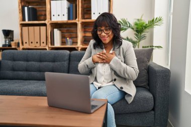 Genç, güzel Latin kadın psikolog psikoloji kliniğinde online seans yapıyor.