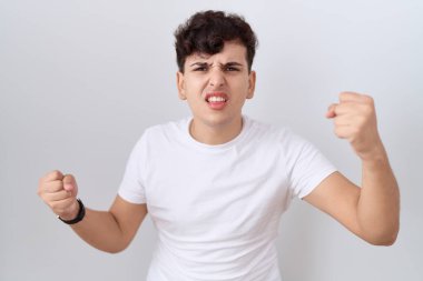 Sıradan beyaz t-shirt giyen genç, öfkeli ve kızgın yumruk kaldıran sinirli ve öfkeyle bağıran bir adam. öfke ve agresif konsept. 