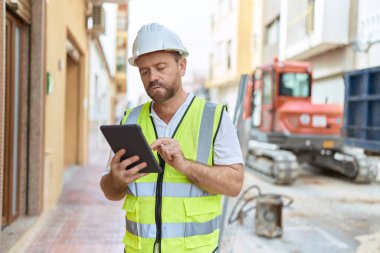 Middle age man architect using touchpad at street