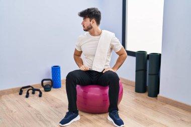 Sakallı İspanyol sakallı bir adam yoga odasında pilatese oturmuş, kendine güveni olan doğal yüzüyle poz veriyor.. 