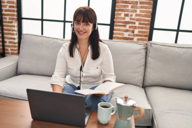 Genç, güzel, İspanyol bir kadın. Çağrı merkezi ajanı. Evde çalışan bir not defteri okuyor.