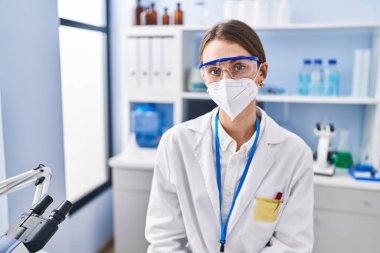 Young caucasian woman scientist wearing medical mask at laboratory
