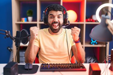 Sakallı, video oyunu oynayan, kulaklıklı İspanyol adam kollarını kaldırıp, gözlerini açarak başarıyı kutluyor. Kazanan konsept. 