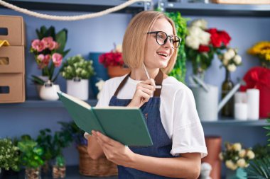 Çiçekçide kendine güvenen genç sarışın bir çiçekçi.