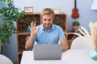 Kafkasyalı bir adam bilgisayarını kullanıyor. Video çekiyor. Pozitif ve mutlu görünüyor. 