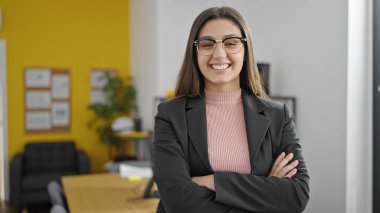 Genç, güzel, İspanyol bir iş adamı. Kendine güler yüzlü. Ofiste kollarını kavuşturmuş duruyor.