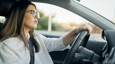 Yolda gözlüklü, güzel, İspanyol bir kadın araba kullanıyor.