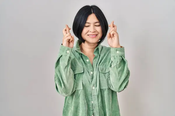 Ung Asiatisk Kvinna Står Över Vit Bakgrund Gestikulerande Finger Korsade — Stockfoto